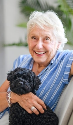Prestonwood Court | Senior woman relaxing at home with her dog