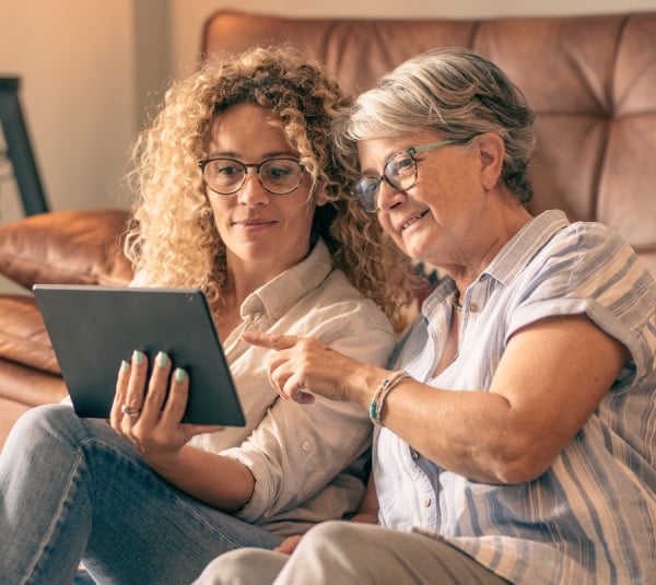 Prestonwood Court | Senior woman and younger woman looking at a tablet