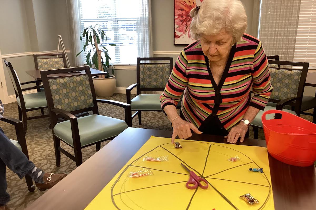 Prestonwood Court | Senior woman spinning the wheel of a memory game